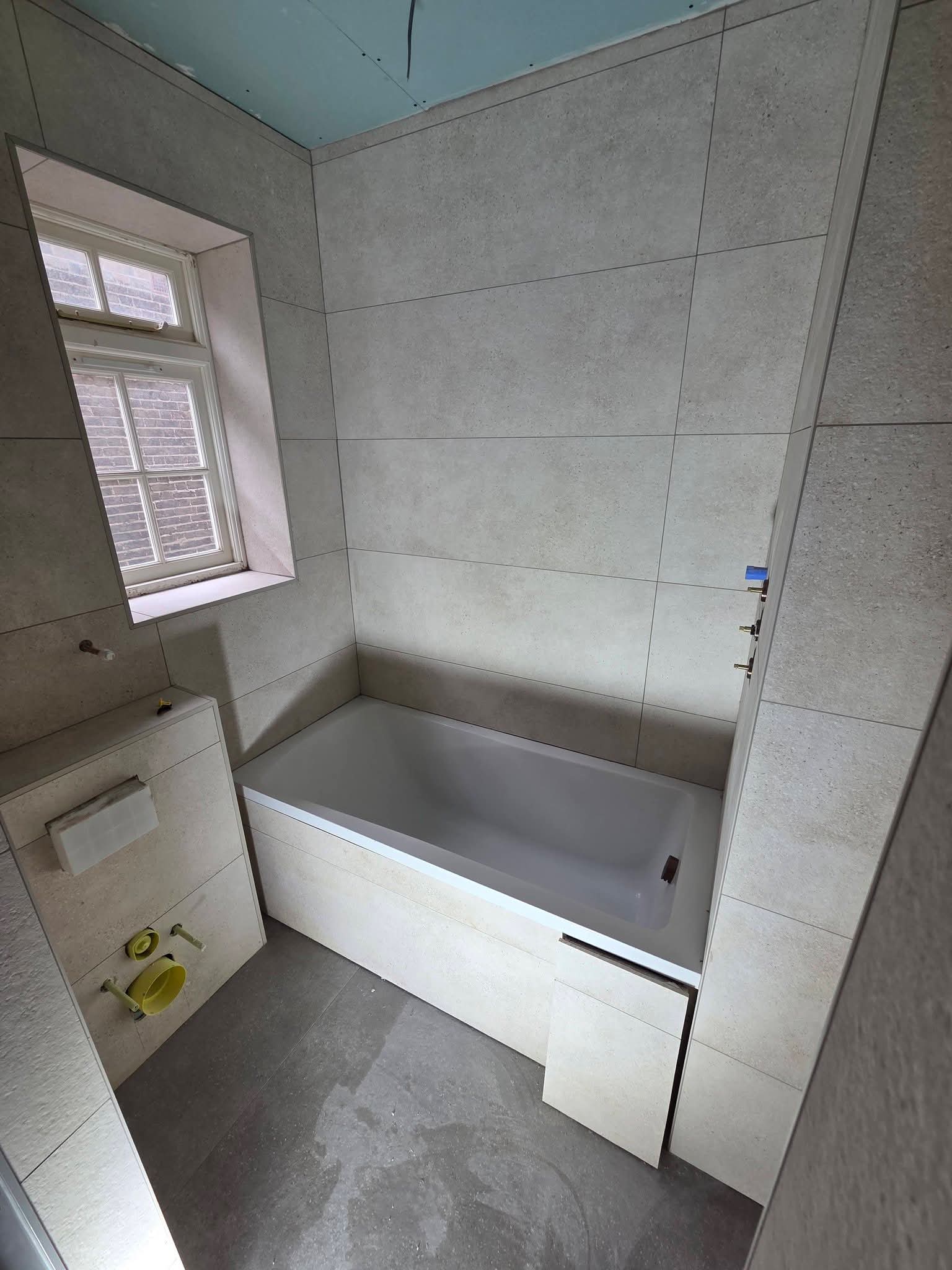 Grey large-format porcelain tiled bathroom with bath