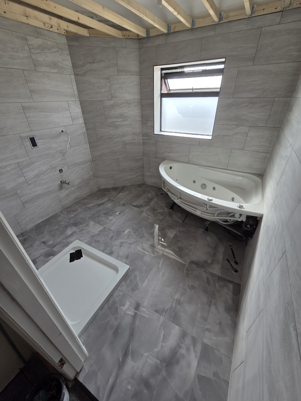 Grey stone-effect large porcelain bathroom tiling by Vanta Tiling, West London